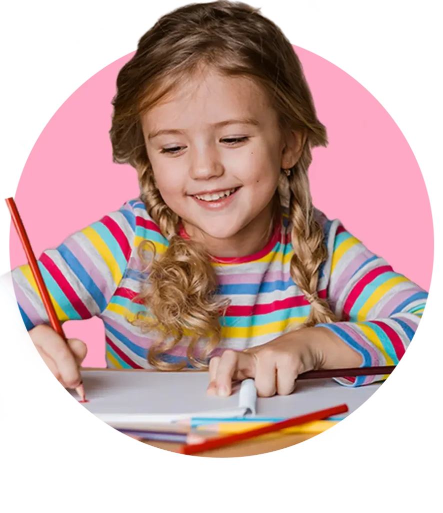 Smiling young girl coloring with pencils on a desk, enjoying coloring pages free printable for kids